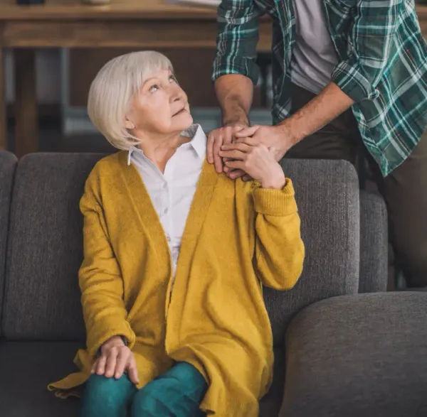 Caregiver gently holding an elderly person's hands